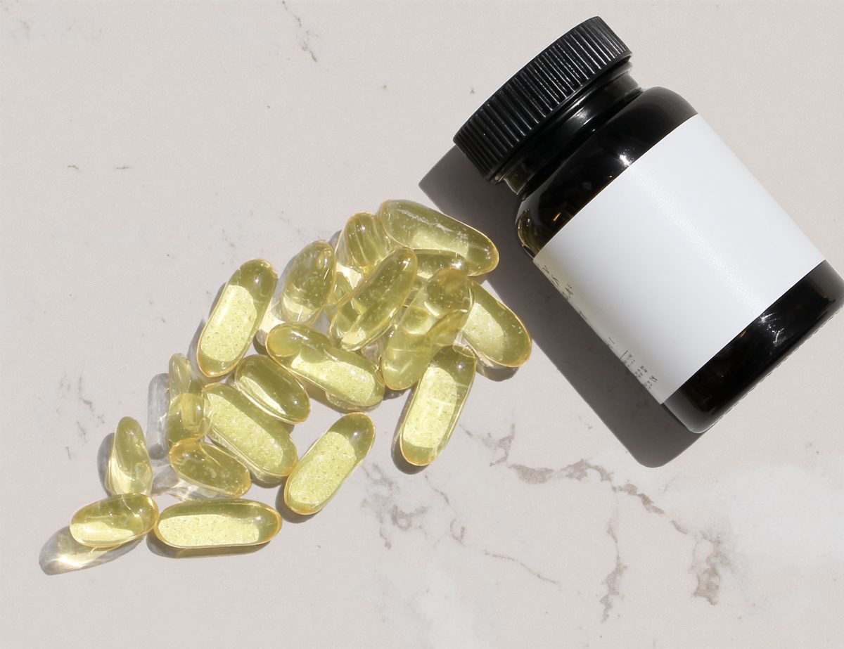 Glass supplement bottle with capsule pills spill